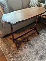 Full view of wooden hall table showing legs, stretcher, and top shape