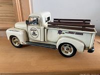 White metal pickup truck model with printed logo and bed rails