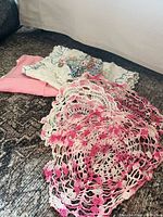 Stack showing white embroidered runner, pink runner, and three pink ombre crocheted doilies