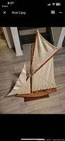 Full view wooden sailboat model with sails and stand