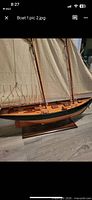 Port side view showing hull, deck, masts, sails, and display stand