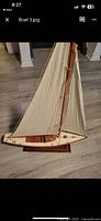 Full view of wooden model sailboat on stand