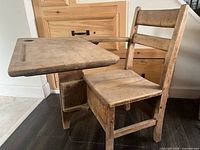 Front view of wooden children’s desk showing attached writing tablet and chair