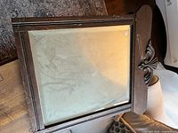 Rectangular dark wood mirror with carved crest detail
