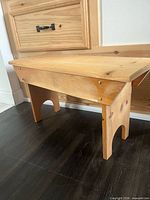 full view of small wooden bench showing seat, supports and finish