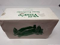 Worn white cardboard box printed "Village Stone Footbridge"