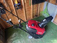 Full view of Honda HS720 snow blower in storage shed
