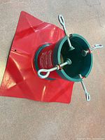 Top view of red plastic base and green collar with four metal eye-bolts