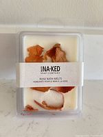 Front of sealed clamshell pack showing Buck Naked Soap Company branding and rose petals in melts