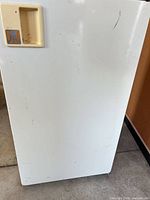 front exterior of fridge showing recessed handle and surface wear