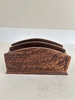 Front view showing ornate carved floral design on stained wood letter holder