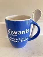 Front view blue Kiwanis mug with spoon in handle