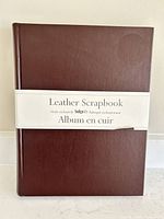 Front of burgundy leather scrapbook with paper band