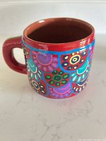 Side view showing full mug, handle, and painted pattern