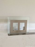 Front view of glass frame showing dual openings and scale with ruler