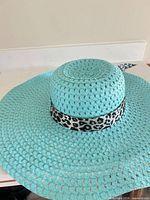 Top view showing turquoise woven straw and leopard ribbon band