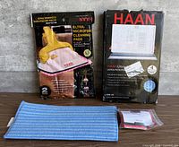 Front view showing both retail packs, loose blue pad, sealed red-trim pad