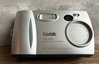 Front view showing lens cover, flash, model markings