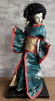 Full view of geisha doll on base showing kimono, pose and overall size