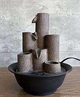 Front view of fountain showing cylindrical columns and basin