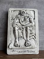 Front view of ceramic bas-relief plaque showing carved figure and signature text