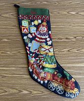 Front of stocking showing needlepoint design and name