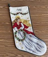 Front of stocking showing needlepoint angel design and name Patty