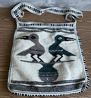 Front view of hand-woven wool tote bag showing bird motif and strap