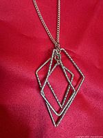 Close-up of pendant showing three layered textured rhombus frames