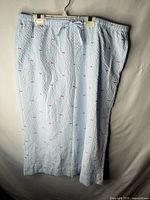 Full view of light blue pajama pants showing embroidered fish pattern and length