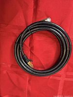Coiled black Cat6 Ethernet cable on red background