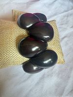 Top view of bracelet displaying large polished dark brown tagua beads on cushion
