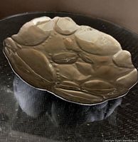 Top view of reflective metal bowl showing irregular shape and finish