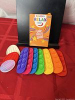 Retail box with eight silicone rainbow fidget bars laid out