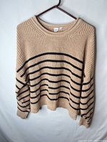 Front view of beige and black striped GAP cotton sweater on hanger
