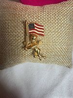 Front view of cherub lapel pin with American flag