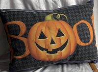 Front of pillow showing jack-o-lantern and BOO on houndstooth background
