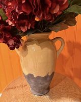 Full view of beige and gray ceramic vase with artificial flowers