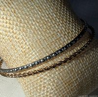 gold-tone rope and silver-tone beaded bangles displayed on stand