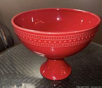 Side view of red footed bowl showing dotted band and pedestal base