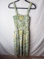 Front view of green, white, yellow floral maxi sundress on hanger