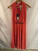 Front view of coral Halston Heritage pleated maxi dress on hanger
