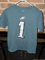 Front view showing number 1 and Eagles logo on green/teal T-shirt