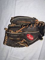 Outer thumb side showing Rawlings oval R logo, tan lacing, The Gold Glove Co. print
