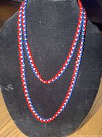 Full view of double-strand red, blue and white beaded necklace on display bust