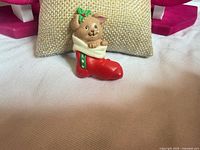 Front view of Russ bunny in red boot holiday pin on cushion