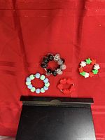 All four beaded fidget rings grouped on red fabric