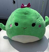 Full frontal view of green cactus Squishmallows plush with bow