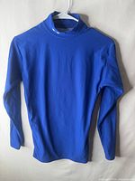 Front view of blue long-sleeve mock neck compression top on hanger