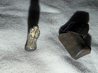 Figurine beside opened protective metal case on fabric background